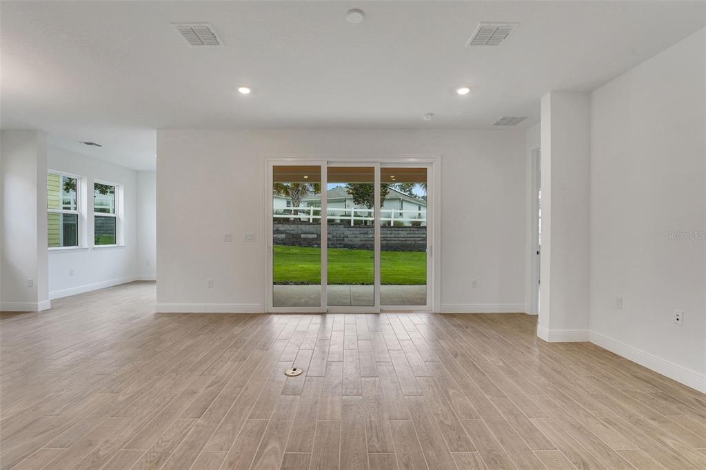 987 Fiesta Key Circle Lady Lake, FL 32159 - Photo 11 of 39 a view of an empty room with wooden floor and a window
