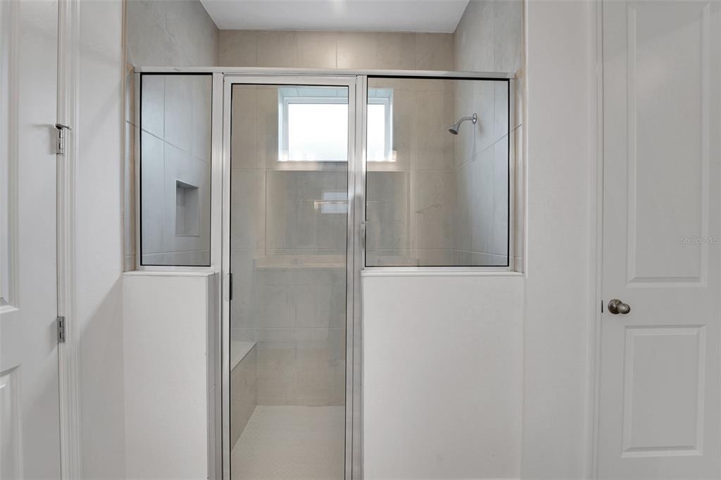 987 Fiesta Key Circle Lady Lake, FL 32159 - Photo 13 of 39 a bathroom with a glass shower door