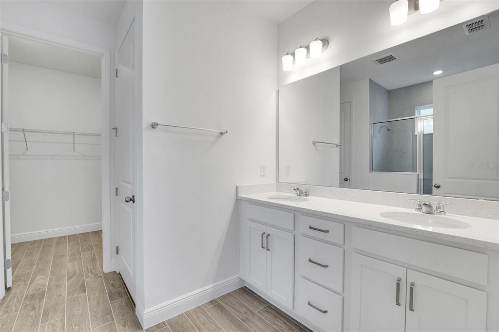 987 Fiesta Key Circle Lady Lake, FL 32159 - Photo 15 of 39 a bathroom with a double vanity sink and mirror