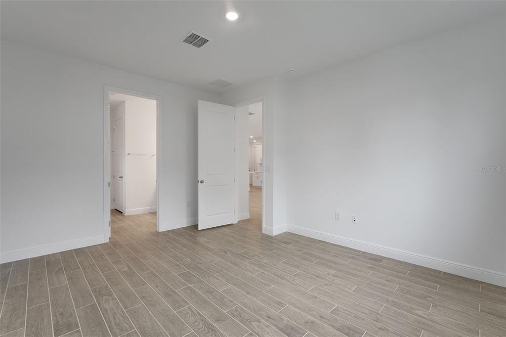 987 Fiesta Key Circle Lady Lake, FL 32159 - Photo 16 of 39 a view of an empty room with wooden floor
