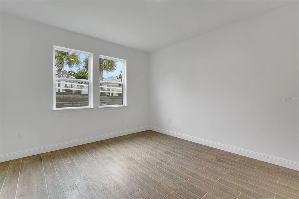 987 Fiesta Key Circle Lady Lake, FL 32159 - Photo 18 of 39 a view of an empty room with wooden floor and a window