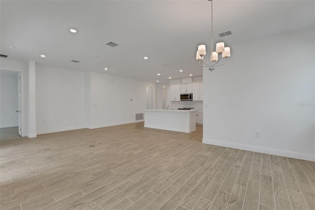 987 Fiesta Key Circle Lady Lake, FL 32159 - Photo 21 of 39 a view of a room with wooden floor and kitchen view