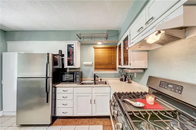 a kitchen with appliances cabinets and a table