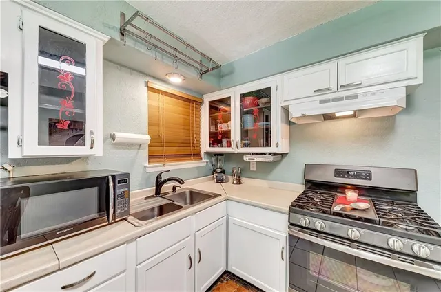 a kitchen with stainless steel appliances a stove sink and cabinets