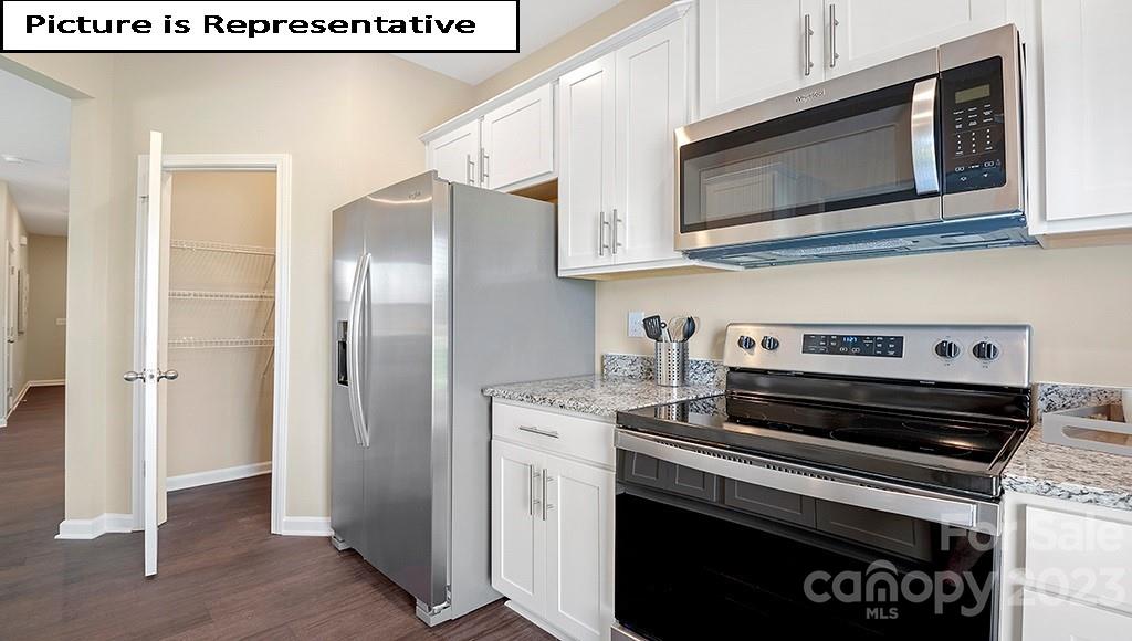 7113 North Mill Road Charlotte, NC 28216 - Photo 13 of 26 a kitchen with stainless steel appliances a stove a microwave and a hard wood floors