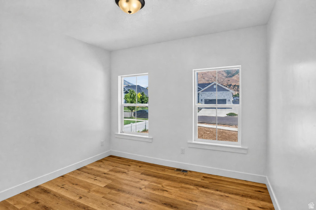 1257 North 1350th Street East Mapleton, UT 84664 - Photo 18 of 34 Wood-finish flooring, two large windows, white walls, and a ceiling-mounted light fixture