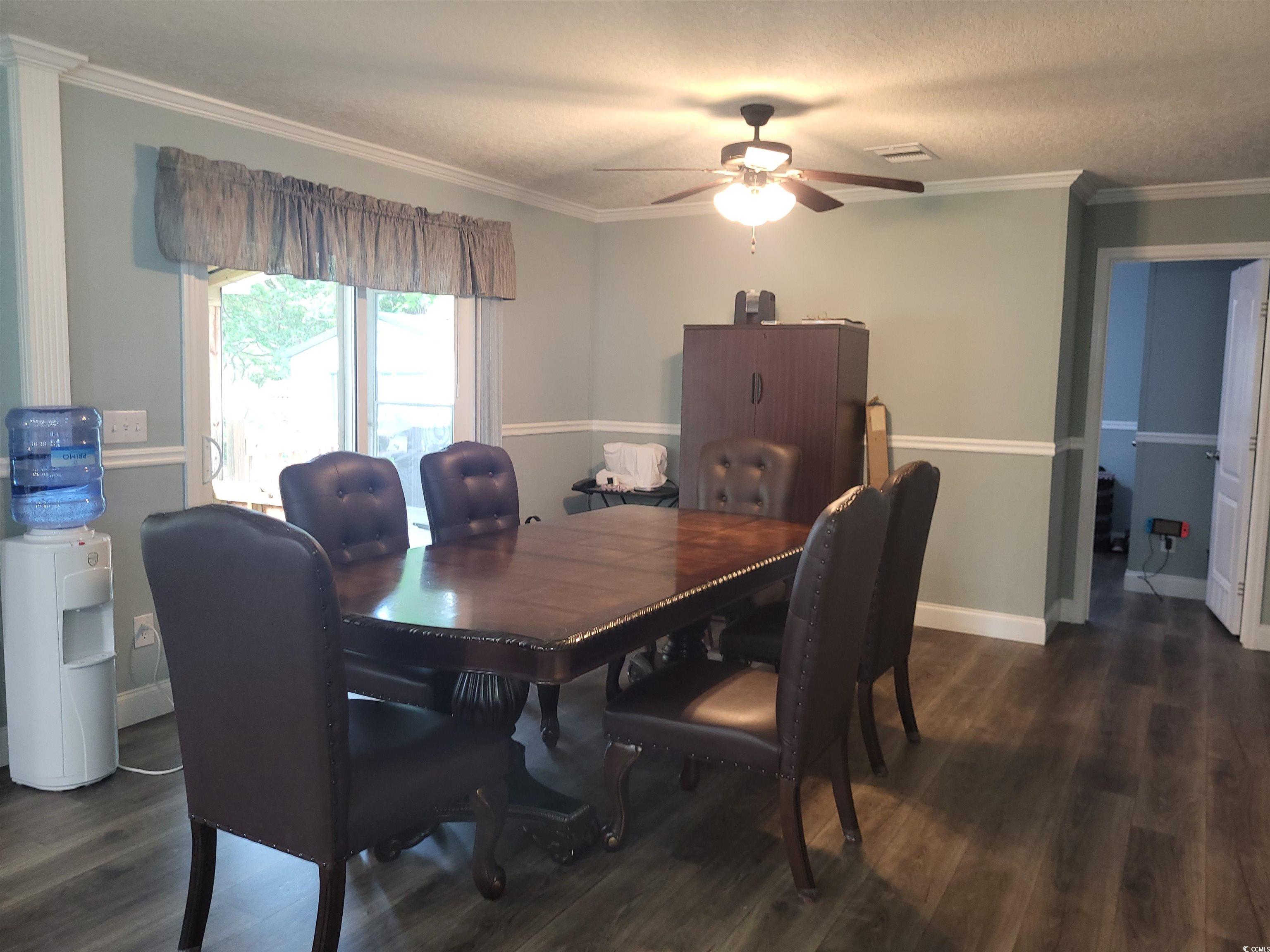 181 Offshore Drive Murrells Inlet, SC 29576 - Photo 10 of 28 Dining space featuring ornamental molding, dark wood-type flooring, ceiling fan, and a textured ceiling