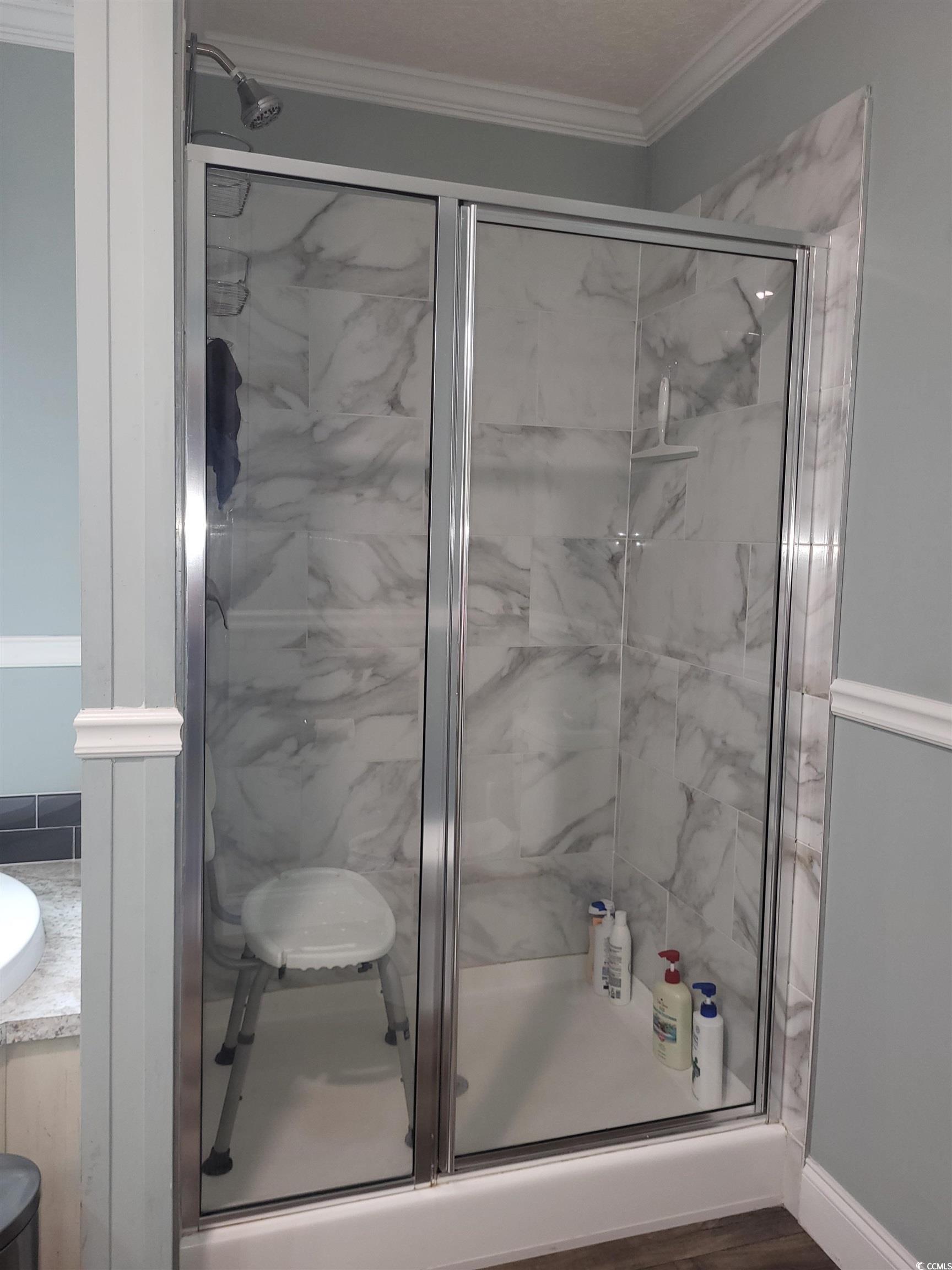 181 Offshore Drive Murrells Inlet, SC 29576 - Photo 14 of 28 Full bathroom featuring a shower stall, ornamental molding, vanity, and dark wood-type flooring