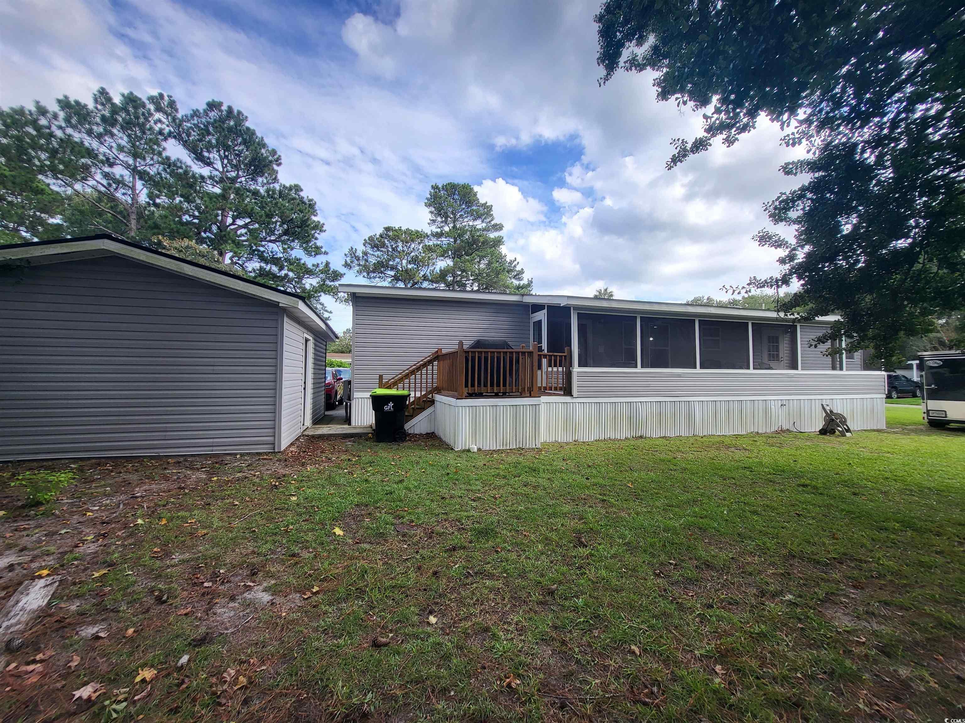 181 Offshore Drive Murrells Inlet, SC 29576 - Photo 24 of 28 Rear view of house with a deck, a yard, and a sunroom