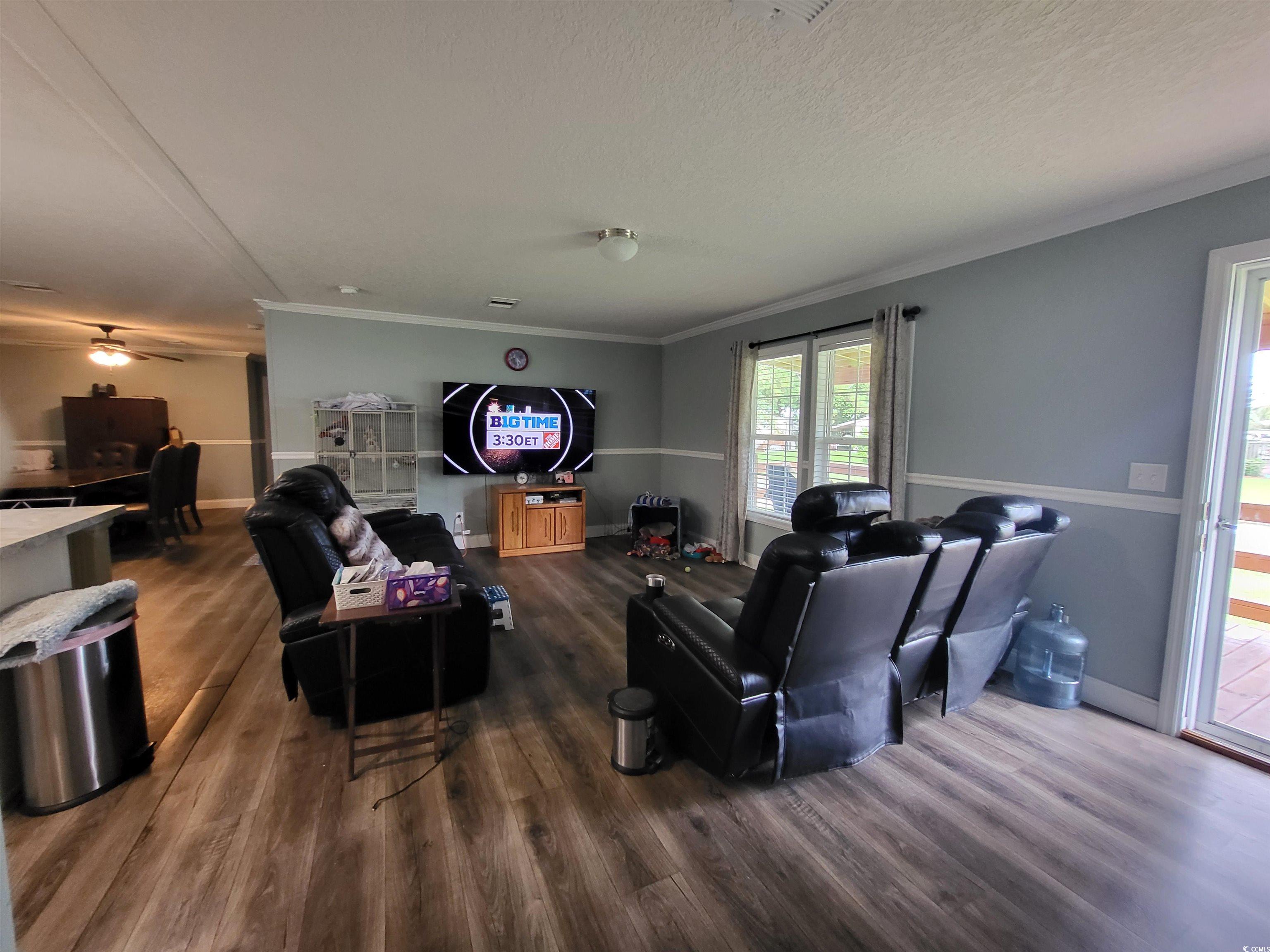 181 Offshore Drive Murrells Inlet, SC 29576 - Photo 5 of 28 Living room featuring crown molding, dark wood-type flooring, ceiling fan, and a textured ceiling