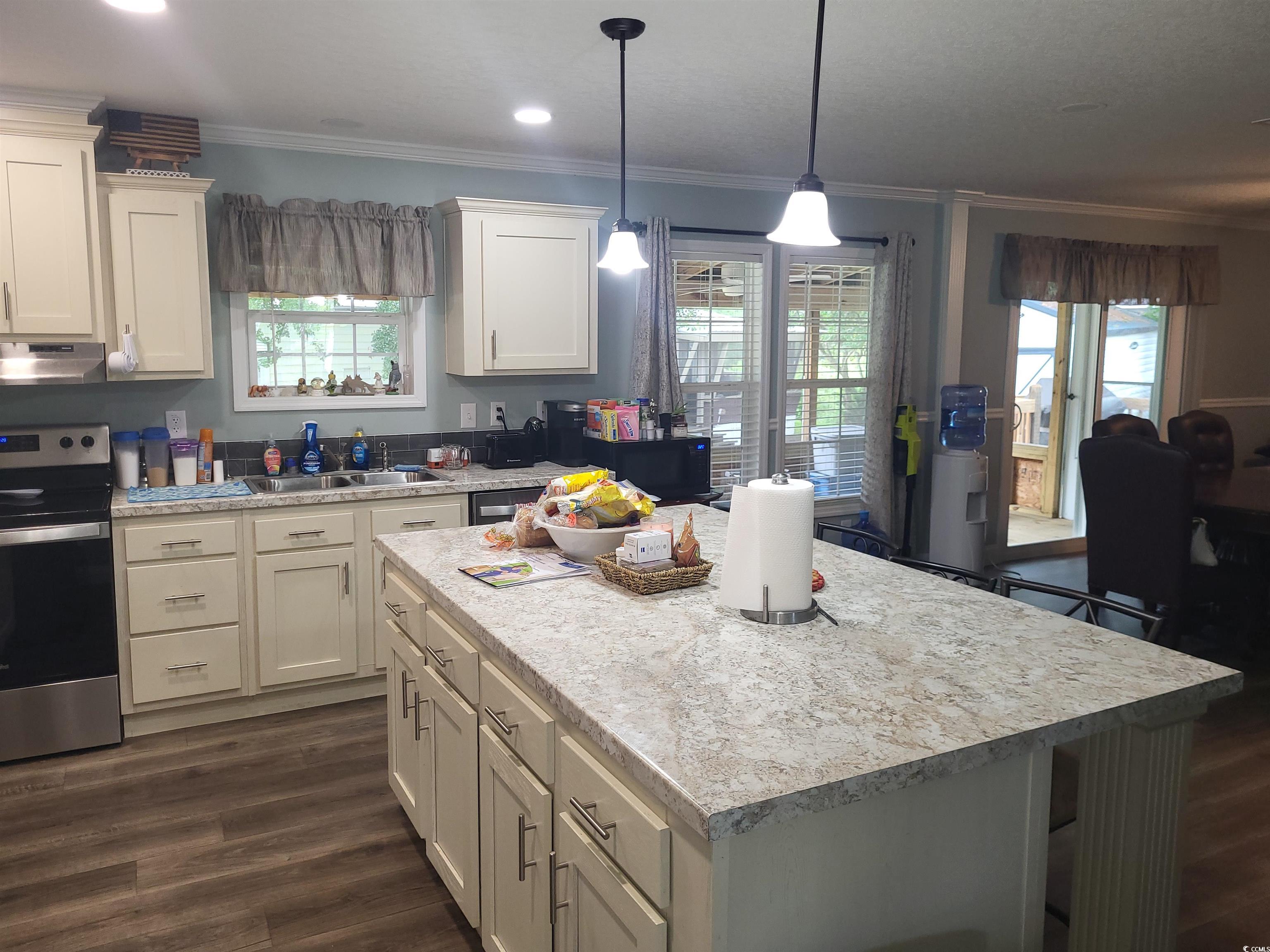 181 Offshore Drive Murrells Inlet, SC 29576 - Photo 7 of 28 Kitchen featuring stainless steel range with electric cooktop, light countertops, ornamental molding, dark wood-style floors, and under cabinet range hood