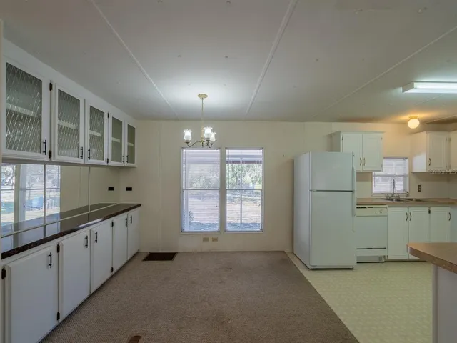 a kitchen with white cabinets and white appliances