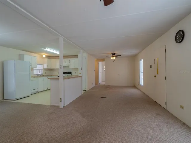 an empty room with closet and a ceiling fan