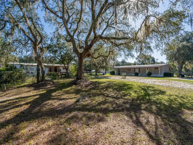 a view of a house with a yard and sitting area