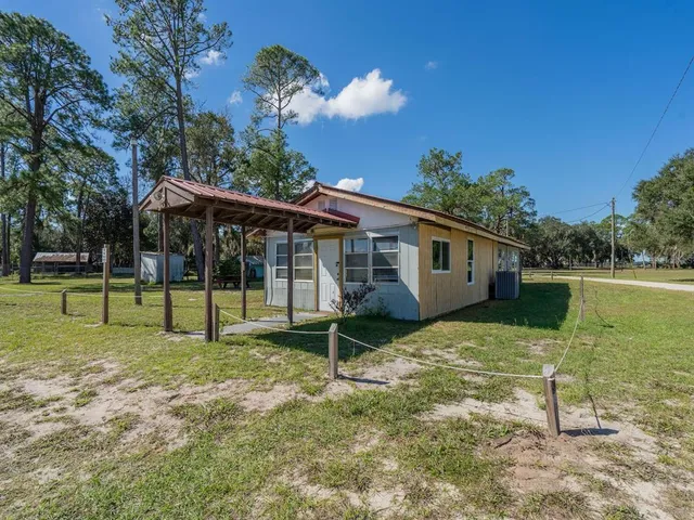 a view of a backyard with floor to ceiling window and wooden fence