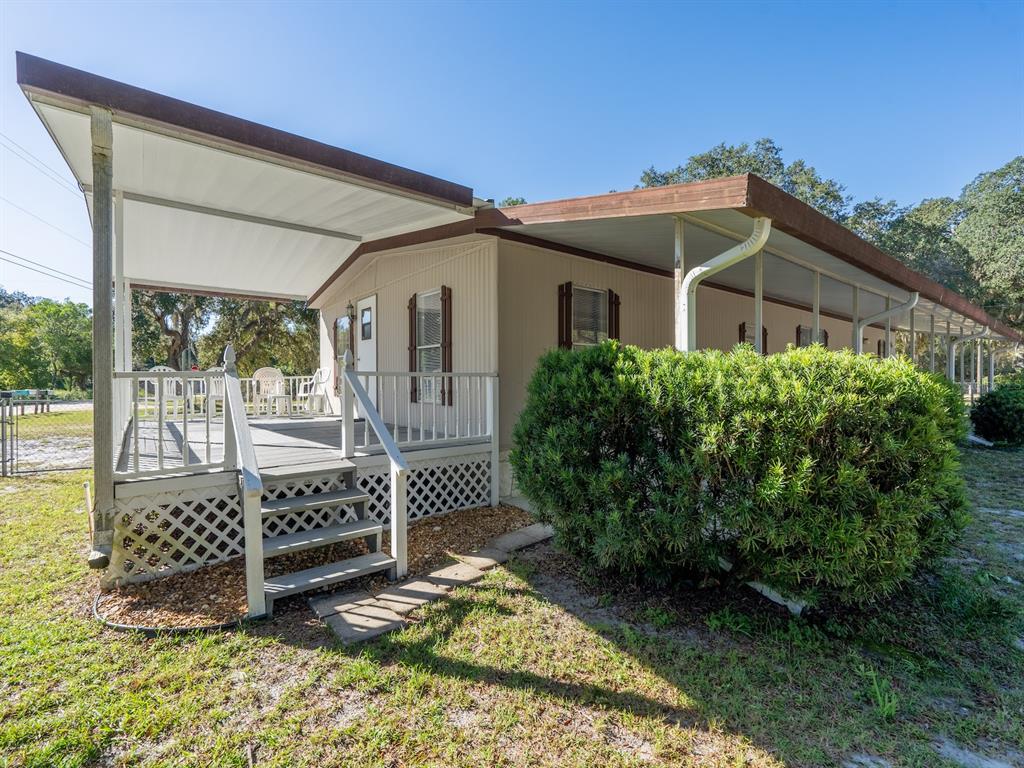 24797 Northeast 135th Street Salt Springs, FL 32134 - Photo 7 of 61 a view of a wooden house with a small yard and wooden fence