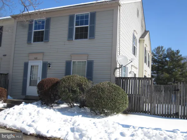 a view of a house with wooden fence in front of house