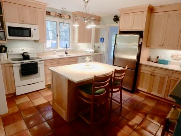 a kitchen with stainless steel appliances a stove a sink a microwave a refrigerator and cabinets