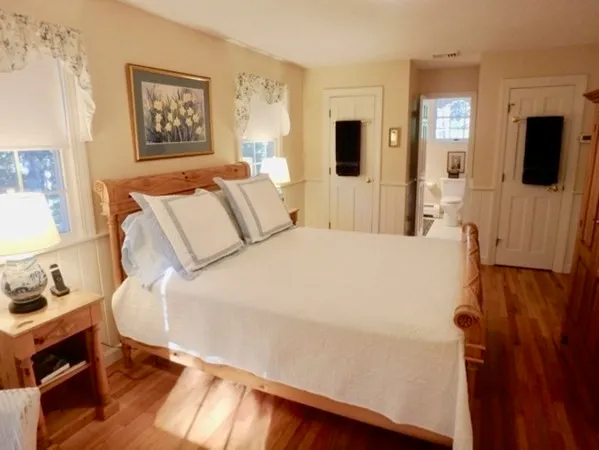 a large bed sitting in a bedroom next to a window