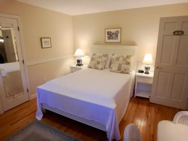 a bedroom with bed and wooden floor