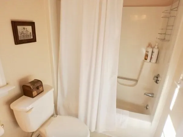 a white toilet sitting next to a bathroom sink and tub