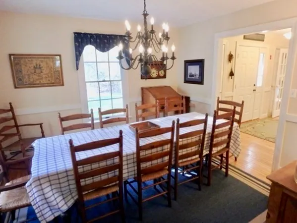 a view of a dining room with furniture a chandelier and wooden floor
