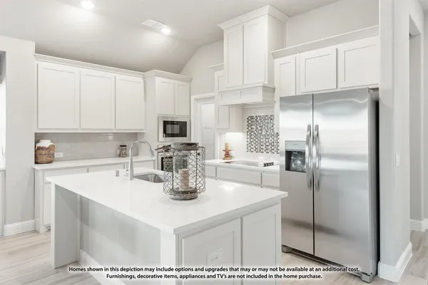 a kitchen with refrigerator and white cabinets