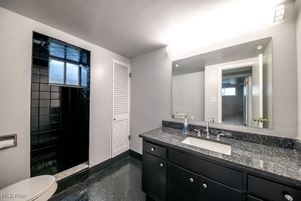 1110 Oak Tree Road Akron, OH 44320 - Photo 17 of 22 Bathroom with toilet, tile flooring, vanity, and tiled shower