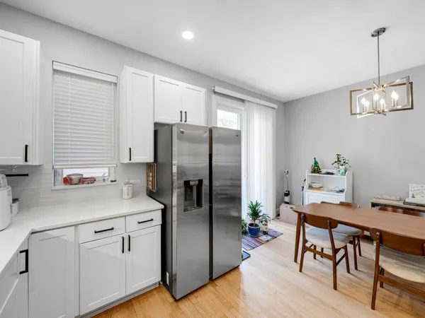 a kitchen with stainless steel appliances white cabinets and wooden floor