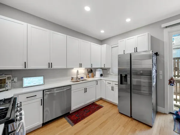 a kitchen with a refrigerator sink and cabinets