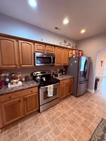 a kitchen with stainless steel appliances a stove a sink a microwave a refrigerator and cabinets