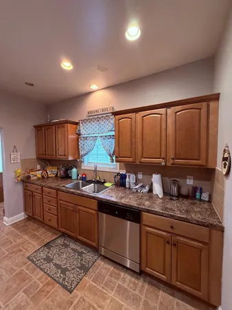 a large kitchen with stainless steel appliances granite countertop a sink stove and cabinets