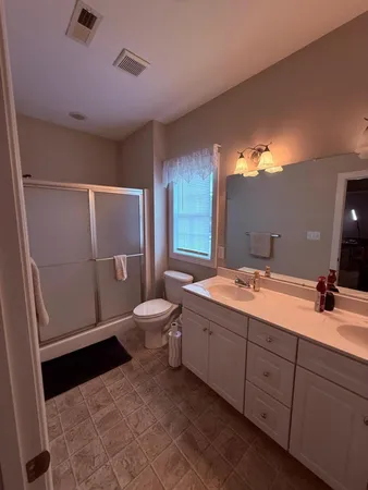 a bathroom with a double vanity sink mirror and toilet