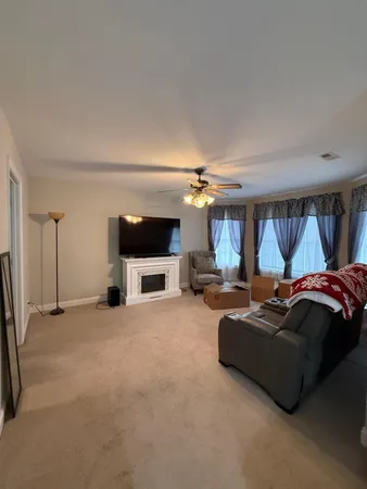 a living room with furniture a chandelier and a flat screen tv