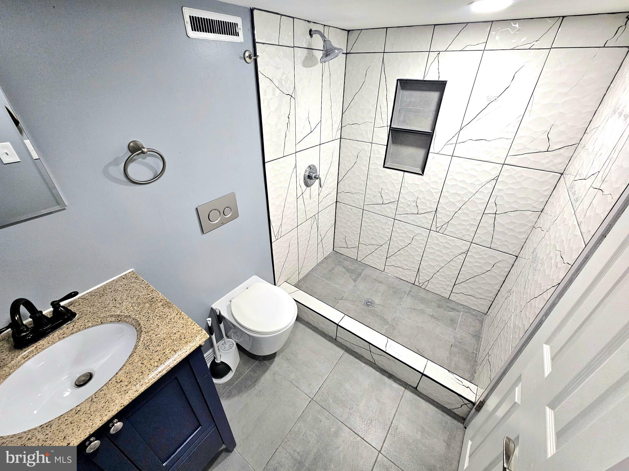 827 South 56th Street Philadelphia, PA 19143 - Photo 29 of 36 a bathroom with a granite countertop sink a toilet and shower