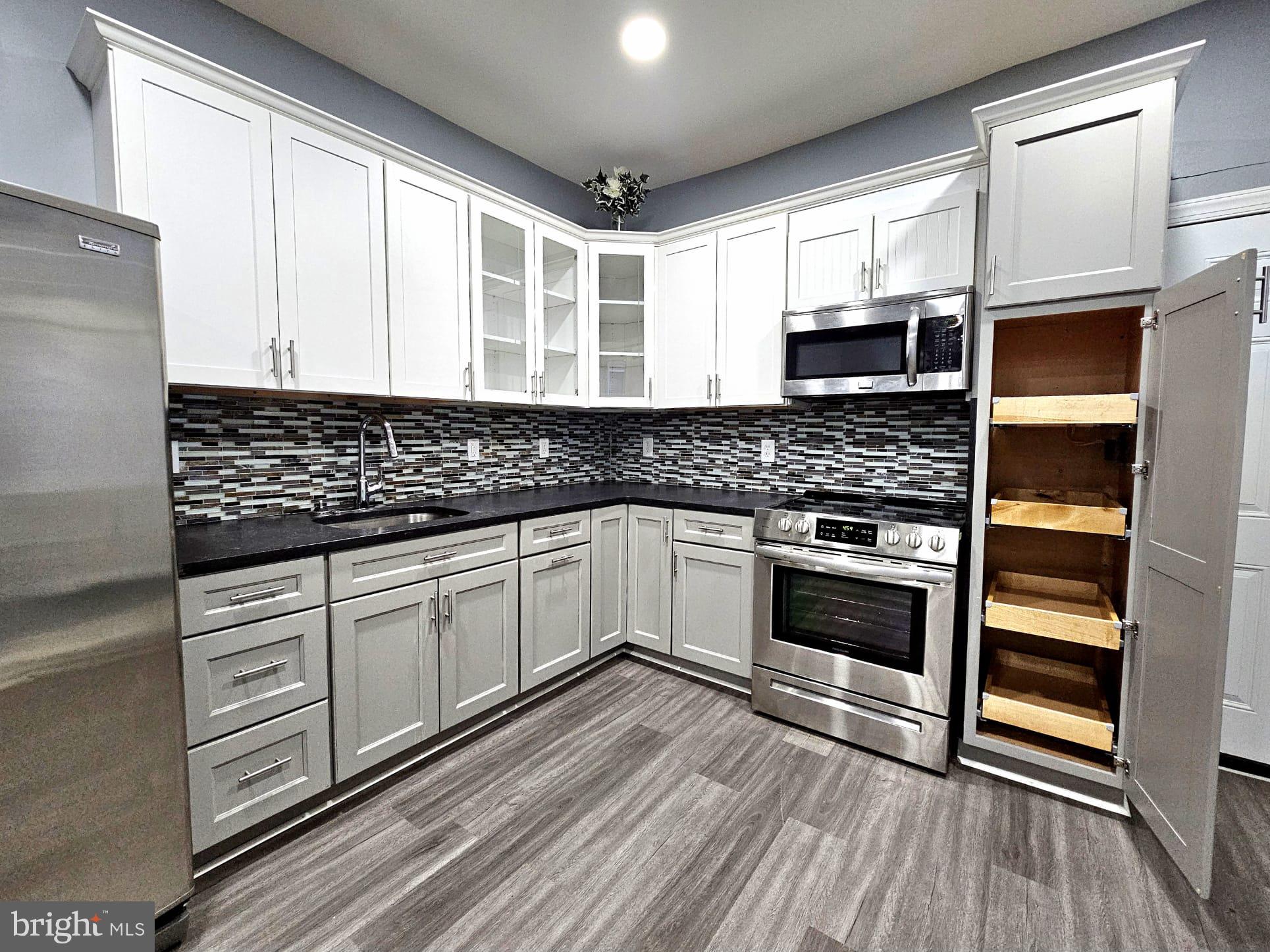 827 South 56th Street Philadelphia, PA 19143 - Photo 9 of 36 a kitchen with stainless steel appliances a stove sink and microwave