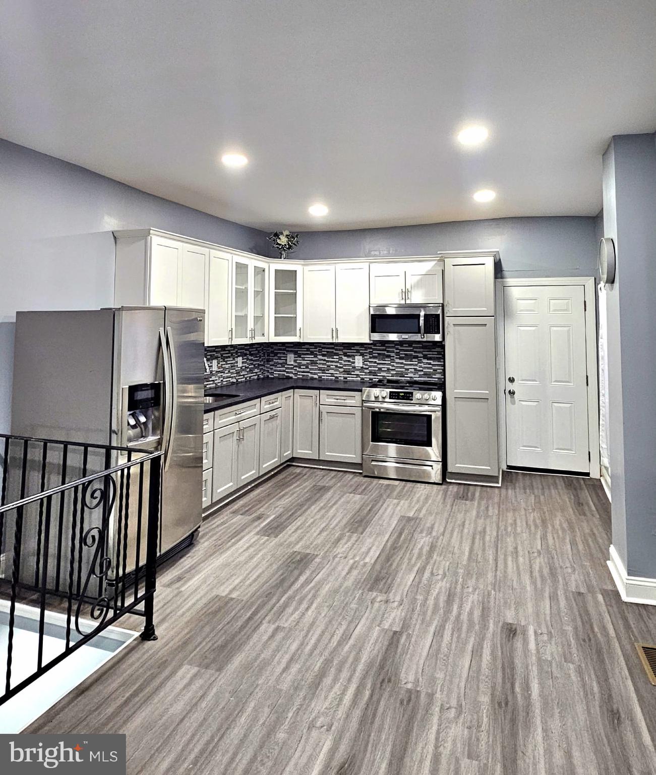 827 South 56th Street Philadelphia, PA 19143 - Photo 10 of 36 a kitchen with stainless steel appliances kitchen island granite countertop a stove and a refrigerator