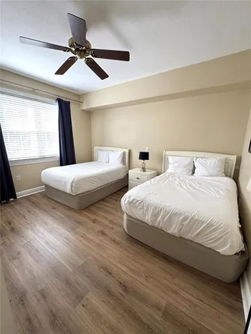 a bedroom with two beds and a ceiling fan