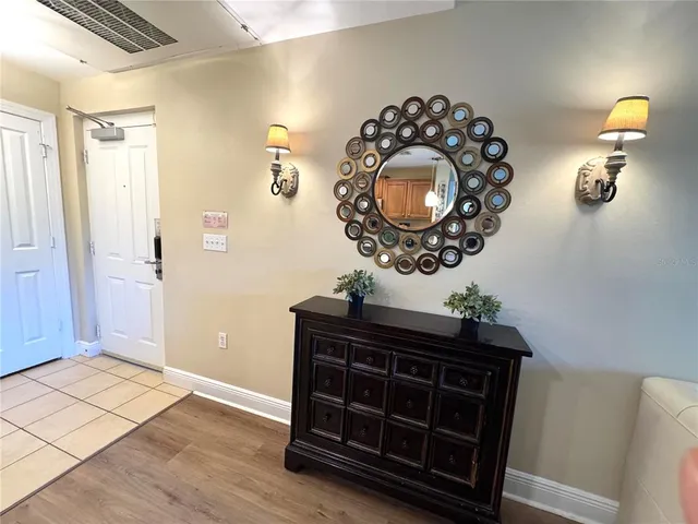a living room with a mirror and a wooden floor