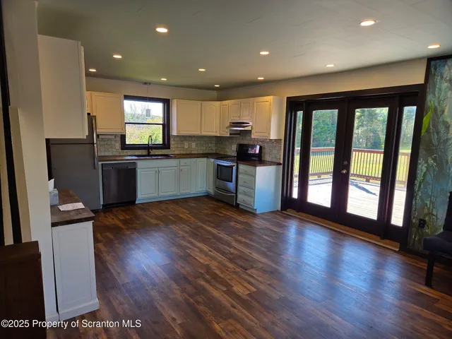 a open kitchen with stainless steel appliances granite countertop a stove top oven a sink and a refrigerator