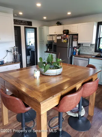 a room with stainless steel appliances dining table and chairs