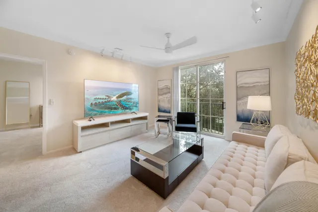 a living room with furniture large window and a flat screen tv