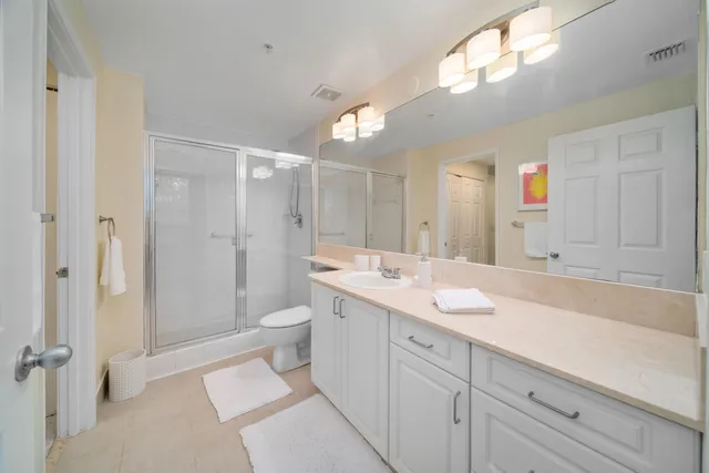 a spacious bathroom with a shower sink and mirror