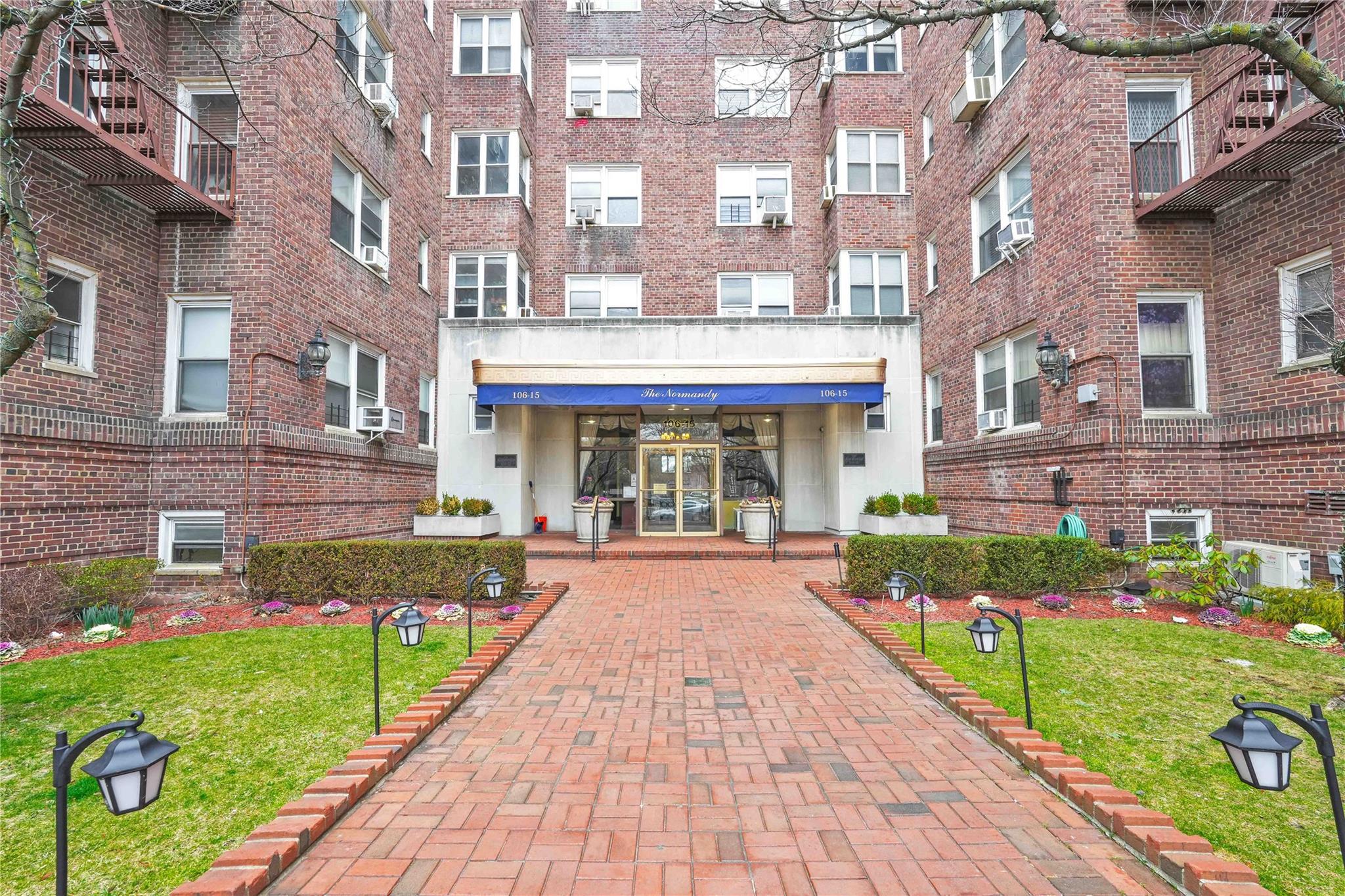 106-15 Queens Boulevard, Unit 1C Queens, NY 11375 - Photo 1 of 23 a front view of a brick building with a yard