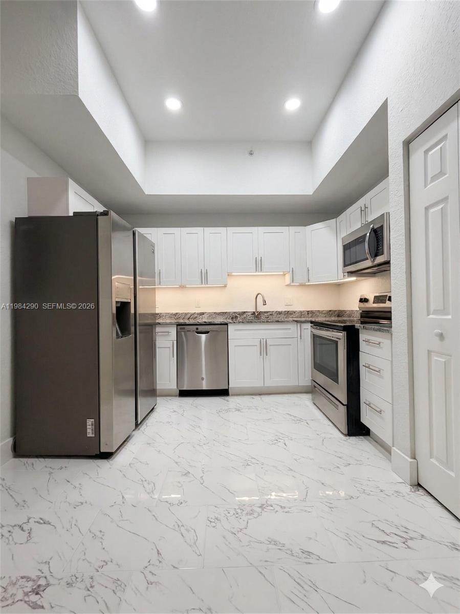 2801 Riverside Drive, Unit 204 Coral Springs, FL 33065 - Photo 2 of 20 a large kitchen with stainless steel appliances granite countertop a refrigerator and a sink