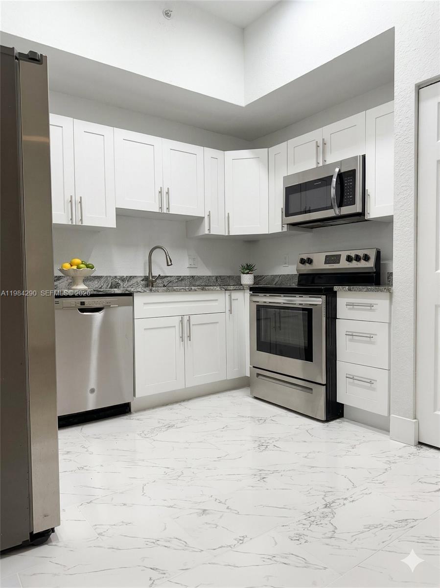 2801 Riverside Drive, Unit 204 Coral Springs, FL 33065 - Photo 3 of 20 a kitchen with stainless steel appliances granite countertop a stove top oven a sink dishwasher and a refrigerator
