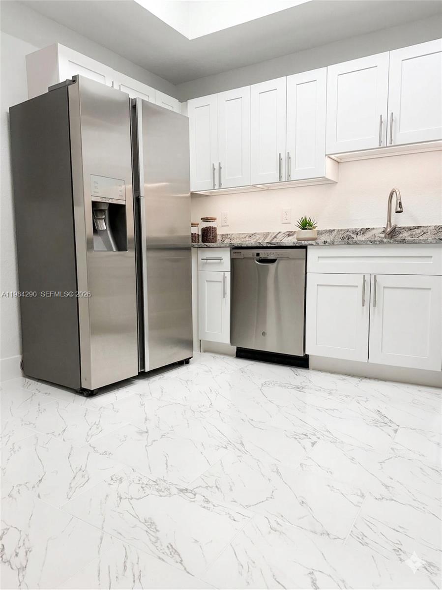 2801 Riverside Drive, Unit 204 Coral Springs, FL 33065 - Photo 4 of 20 a kitchen with granite countertop white cabinets and stainless steel appliances