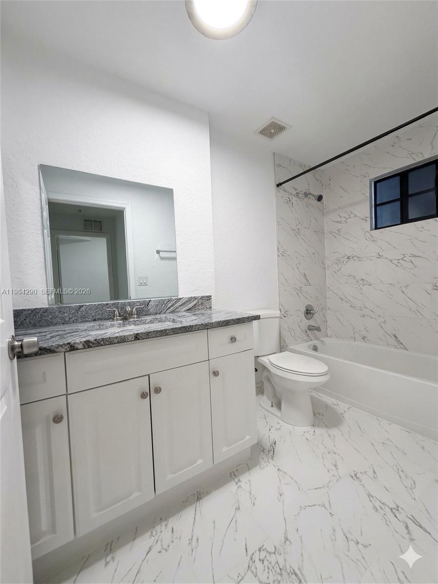 2801 Riverside Drive, Unit 204 Coral Springs, FL 33065 - Photo 9 of 20 a bathroom with a granite countertop sink a toilet and bathtub