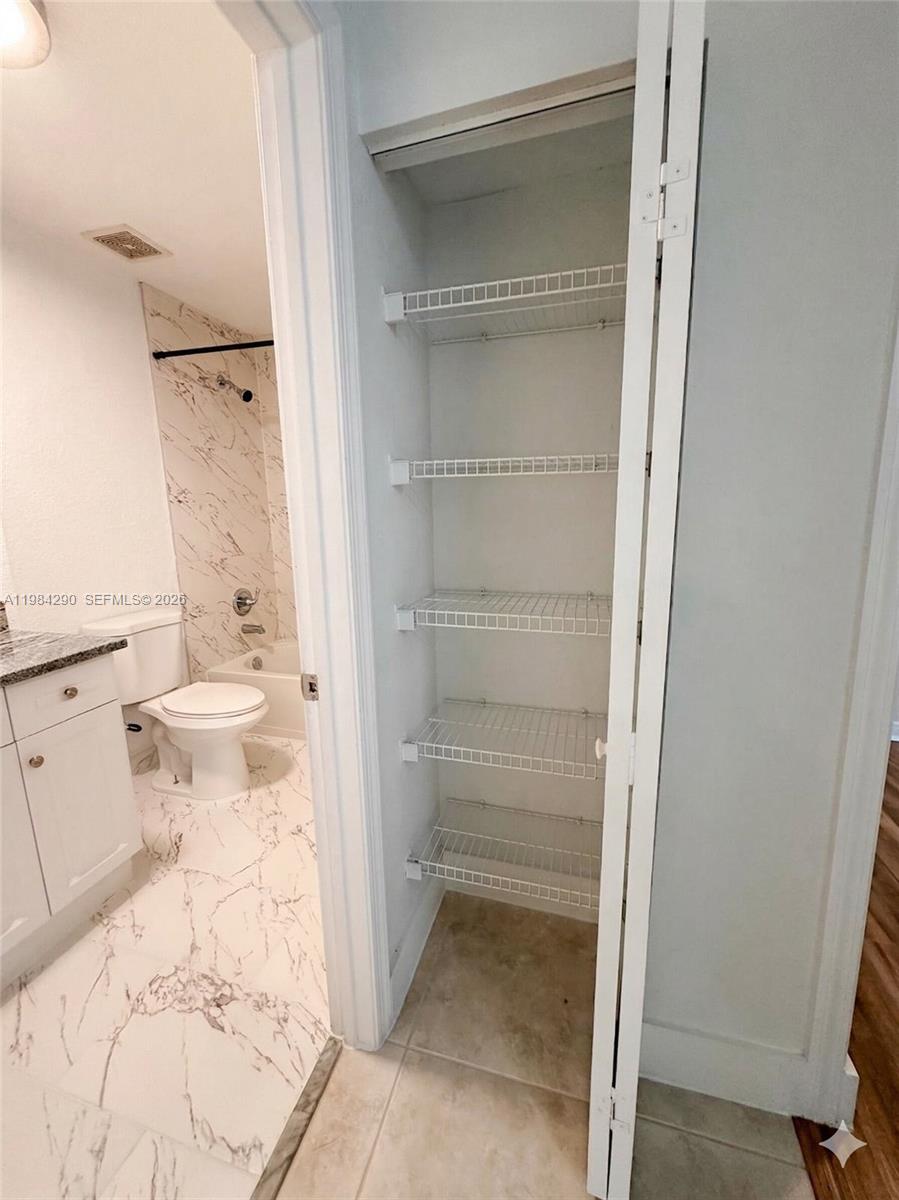 2801 Riverside Drive, Unit 204 Coral Springs, FL 33065 - Photo 10 of 20 a bathroom with a granite countertop sink toilet and shower