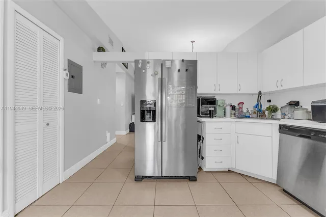 a kitchen with white cabinets and stainless steel appliances